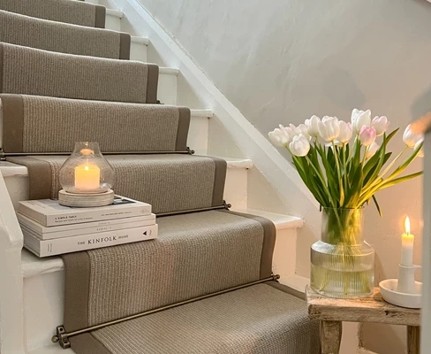 Beige wool stair runner with brass carpet rods