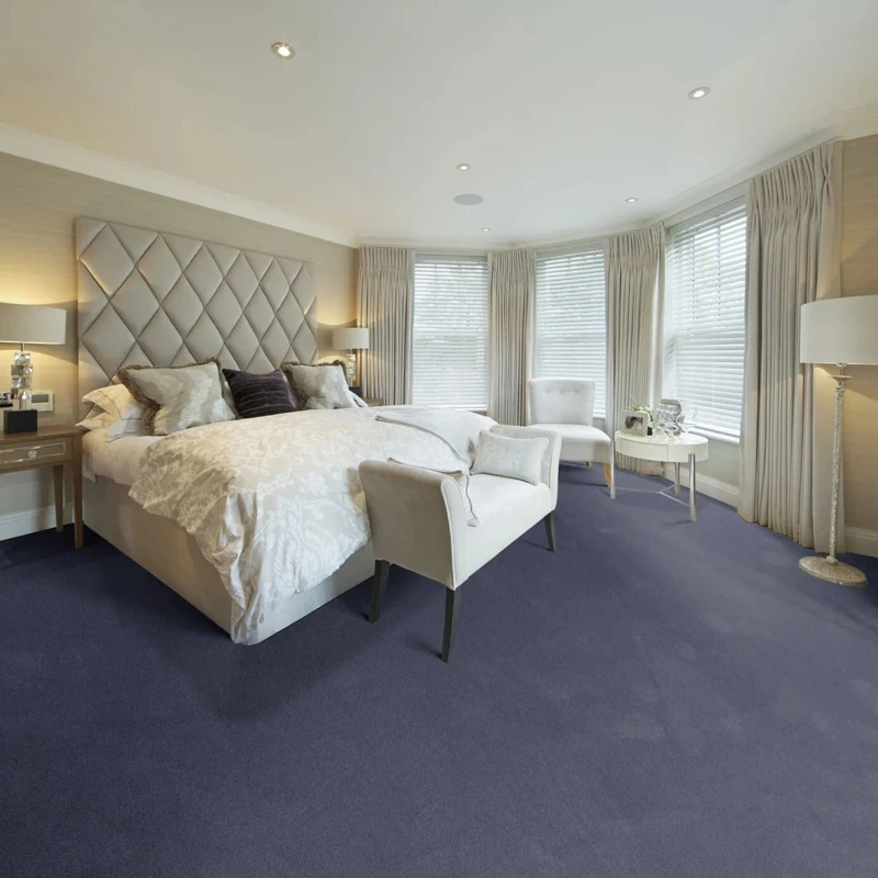 Deep navy plush carpet in a luxury bedroom with a tufted headboard.