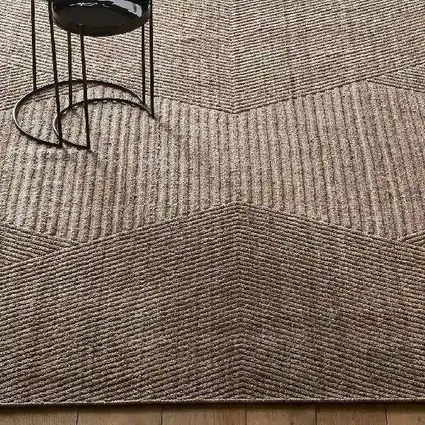 Textured taupe wool carpet with a geometric chevron ribbed pattern.