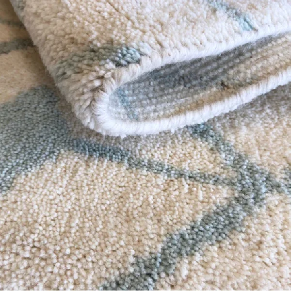 plush cut pile wool carpet in cream with a light blue geometric pattern.